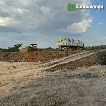 รถบรรทุกดินบนพื้นที่ถม พร้อมแนวทางรถและกองดิน